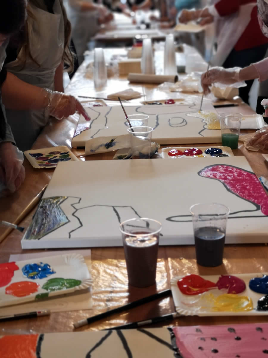Künstlerischer Teambuilding Workshop mit Farben, Pinseln und gemeinsamer Teamarbeit